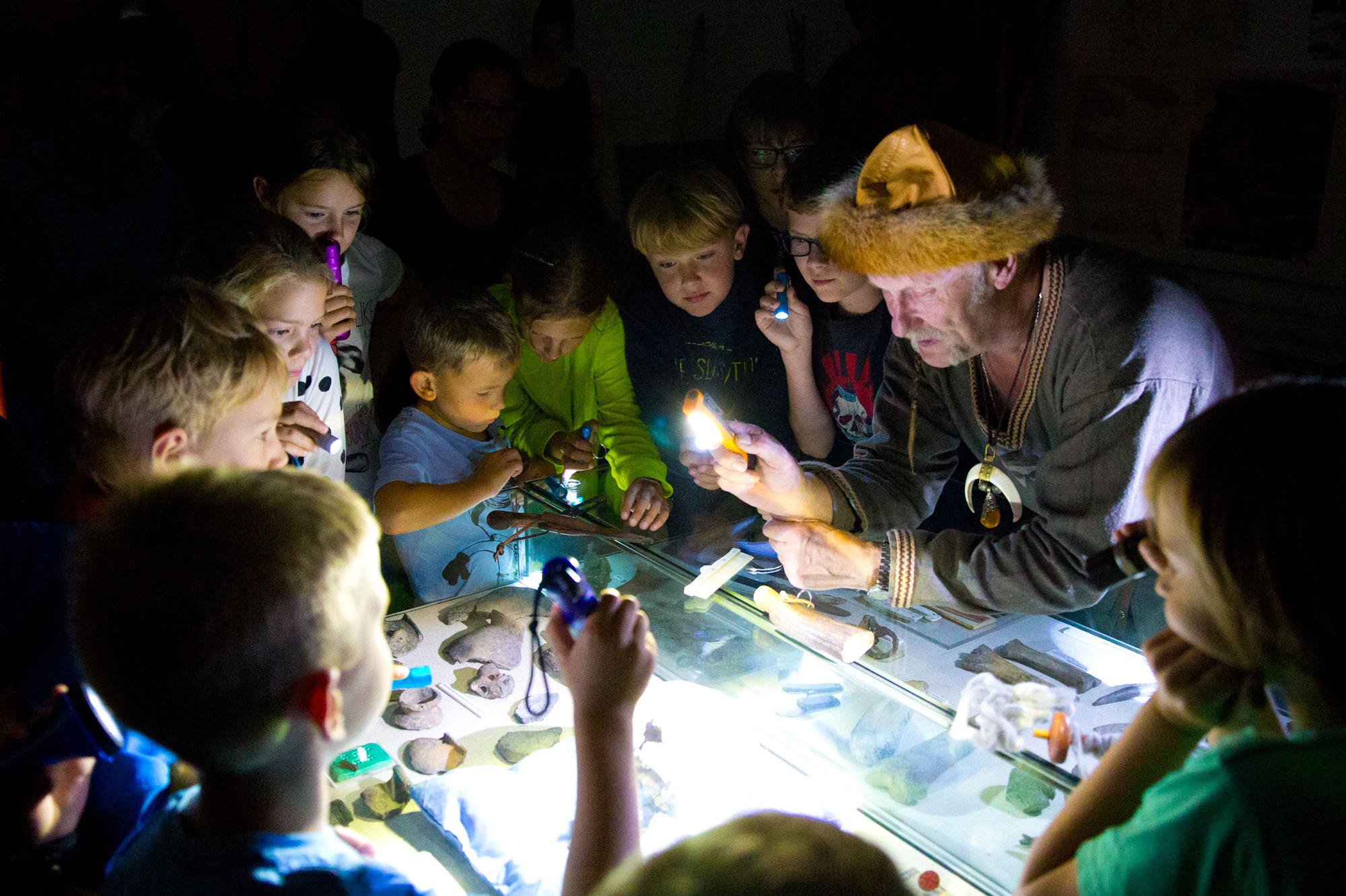 Gruppe von Kindern mit Taschenlampen im Museum